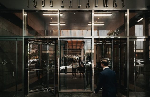 Homem de terno entra na entrada de vidro da Morgan Stanley, 1585 Broadway.