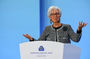 Christine Lagarde discursa em pódio do Banco Central Europeu (BCE), gesticulando com as mãos abertas.