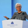 Christine Lagarde discursa em pódio do Banco Central Europeu (BCE), gesticulando com as mãos abertas.