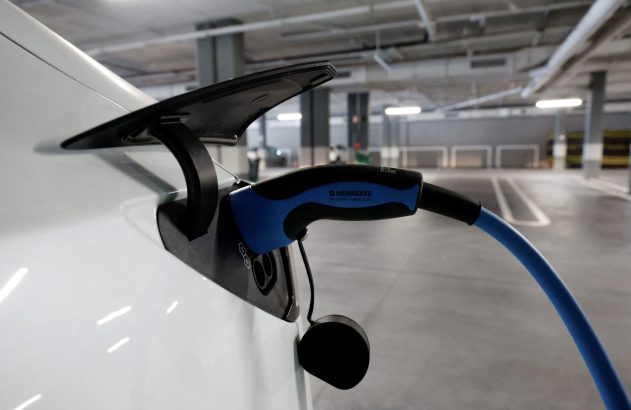 Carro elétrico branco sendo carregado.