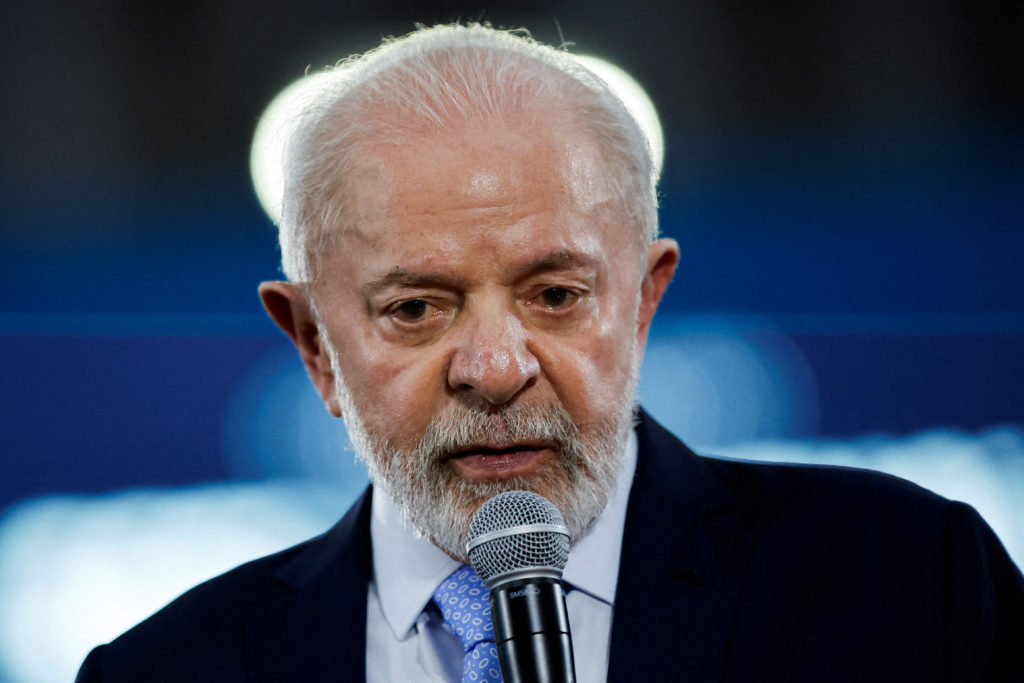 Presidente Lula, com cabelo e barba brancos, fala ao microfone.