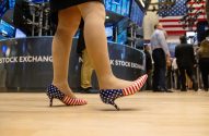 Pernas com sapatos da bandeira americana, caminhando em piso de bolsa de valores.