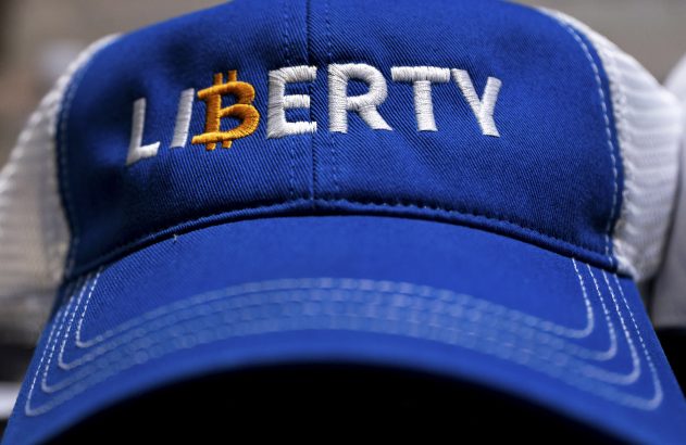 Boné azul com 'LI₿ERTY' bordado. 'LI' e 'ERTY' em branco; símbolo de Bitcoin (₿) dourado.