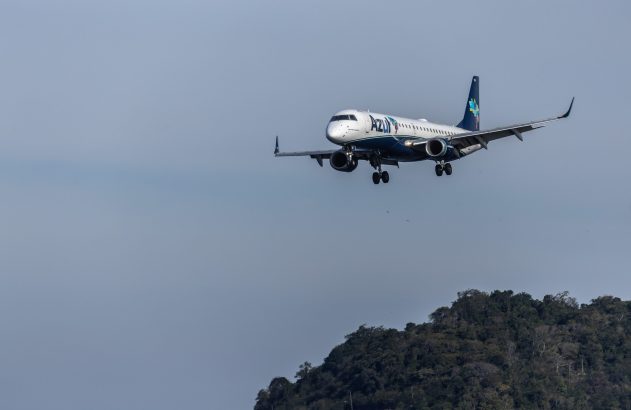 Avião da Azul em aproximação de pouso sobre montanhas. Céu cinzento.