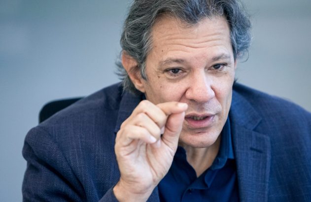 Homem de cabelos grisalhos gesticulando ao falar, com polegar e indicador juntos.