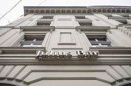 Edifício com fachada em tons claros, visto de baixo, exibindo o letreiro "Julius Bär".