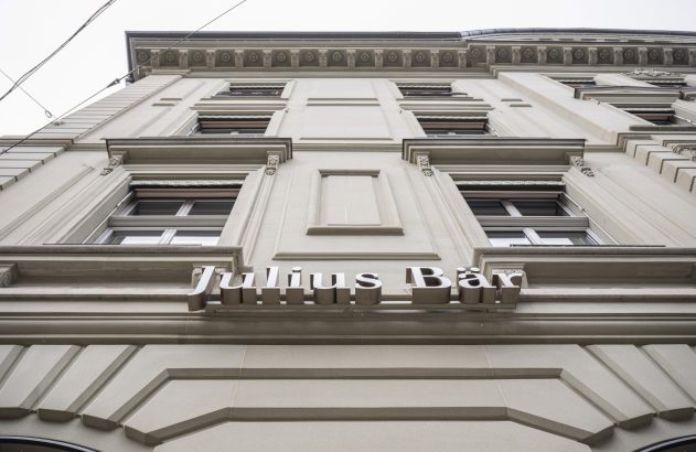 Edifício com fachada em tons claros, visto de baixo, exibindo o letreiro "Julius Bär".