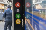 Homem de costas em rua, próximo a painel refletivo com logos de criptomoedas: Bitcoin, Ethereum, Tether e Binance.