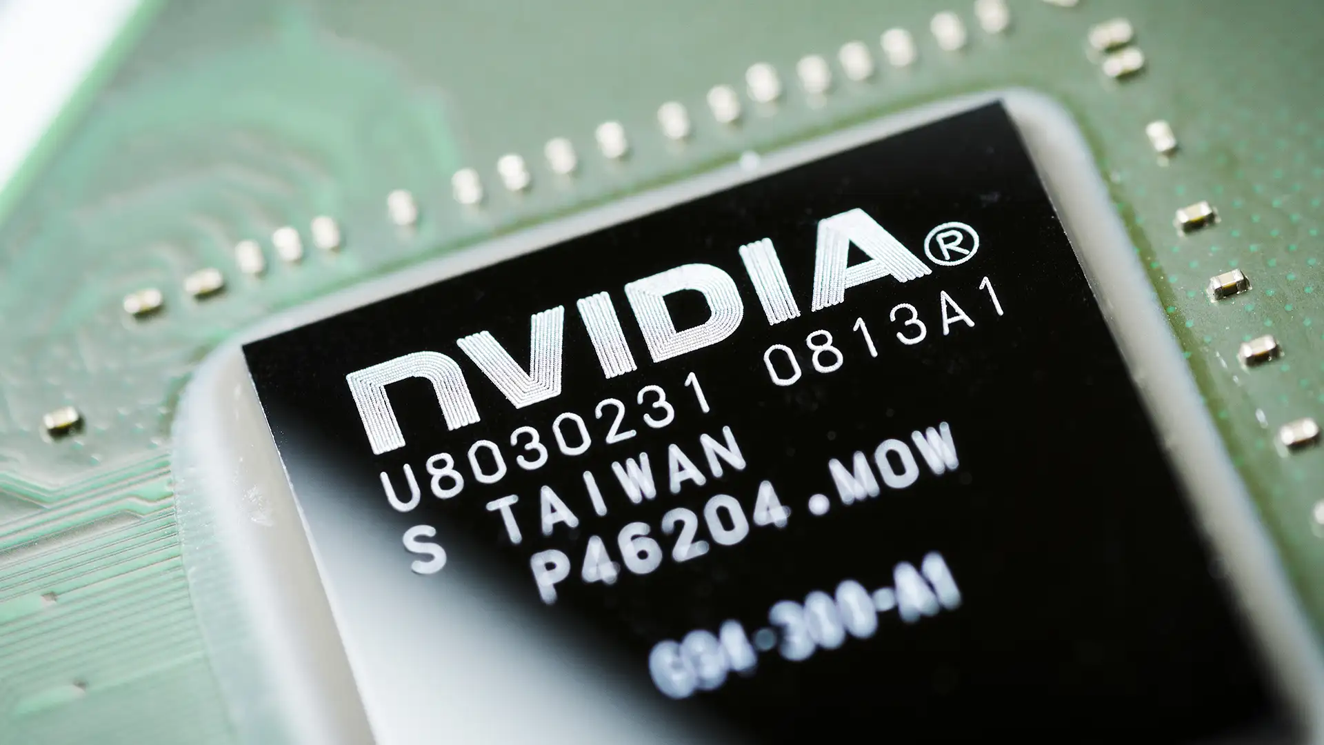 Close-up de um chip eletrônico integrado da NVIDIA com códigos alfanuméricos e inscrição de fabricação em Taiwan sobre uma placa de circuito verde.