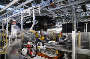 Cena de fábrica automatizada: carrocerias de veículos e robôs industriais em alta velocidade na linha de montagem.