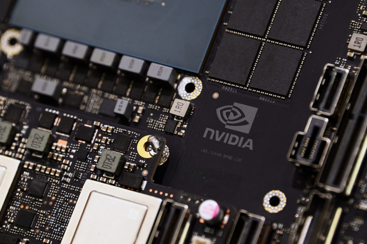Placa de circuito preta com componentes eletrônicos, logo NVIDIA e uma área de montagem carbonizada.