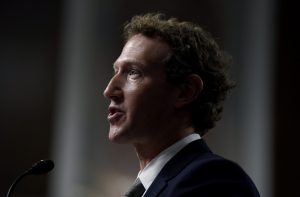 Mark Zuckerberg de perfil esquerdo, falando em um microfone.