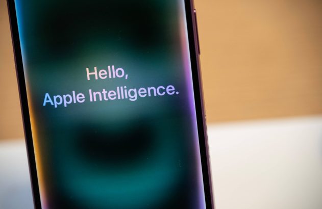 Celular com texto 'Hello, Apple Intelligence' na tela, sobre fundo turvo.