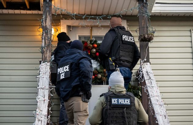 Agentes da Polícia e ICE em varanda de casa com decoração natalina, se aproximando da porta.