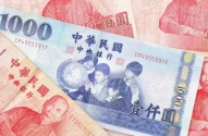 Cédulas de dinheiro taiwanês com destaque para uma cédula azul de 1000 novos dólares taiwaneses e cédulas vermelhas de 100 novos dólares taiwaneses ao fundo.