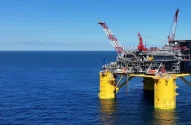 Plataforma de petróleo flutuante no oceano sob céu azul.