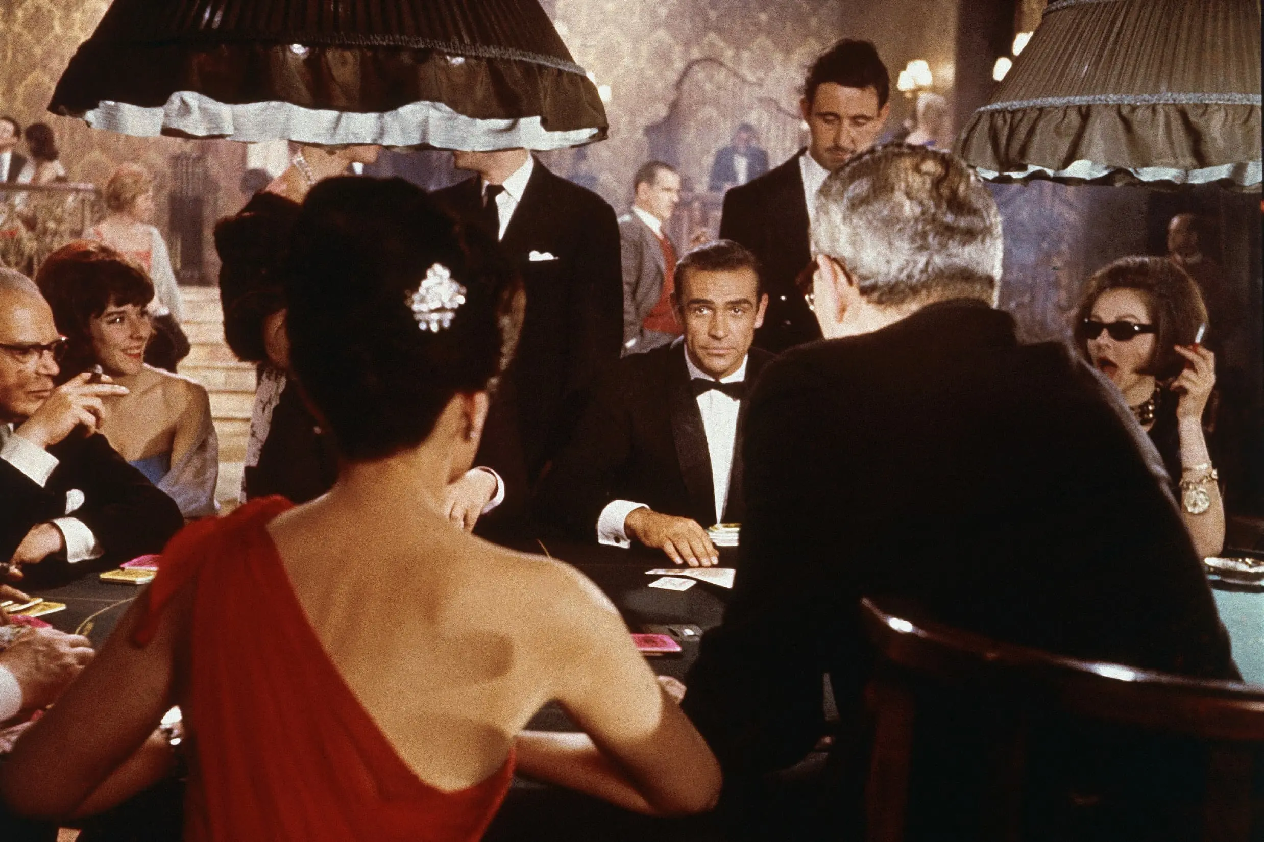 Sean Connery, como o agente secreto James Bond, sentado em uma mesa de jogo de cassino em uma cena do filme 'Dr. No.'