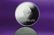 Imagem de uma moeda prateada de Ethereum com seu logotipo tridimensional característico, sobre uma superfície refletiva, destacada por um fundo roxo.