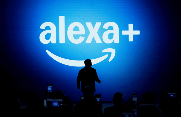 Pessoa em palco à frente de tela azul com 'alexa+' e logo Amazon. Apresentação tech. (94 caracteres)