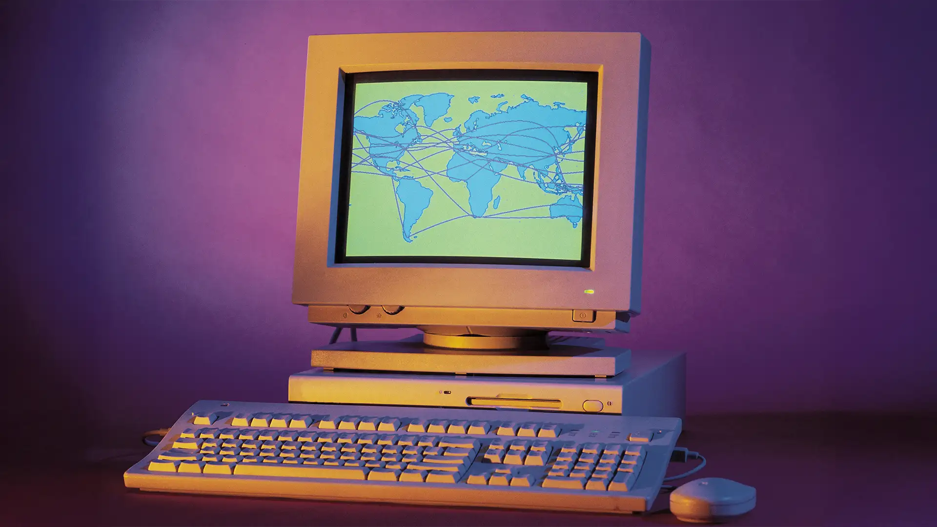 Imagem de um computador retro, com monitor CRT exibindo um mapa-múndi interconectado, em fundo roxo nostálgico.