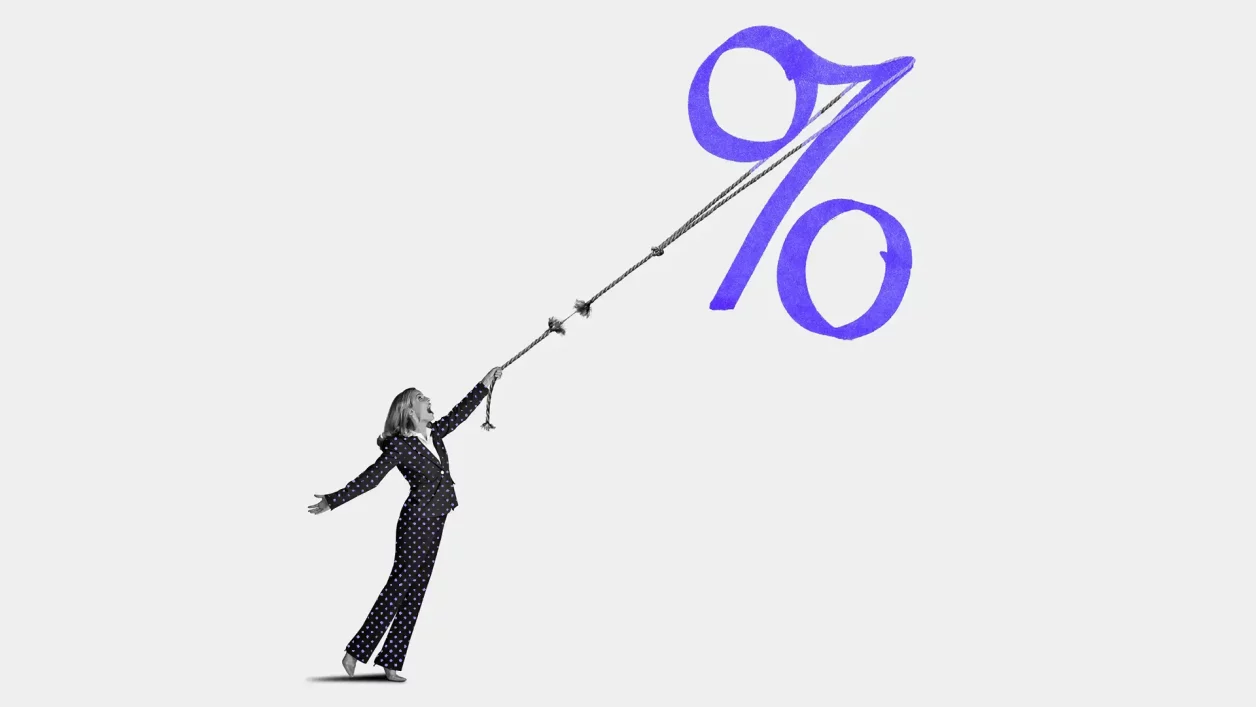 Mulher em terno puxa com esforço uma corda que se rompe, presa a um grande símbolo de porcentagem.