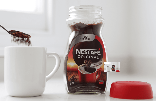 Pote de Nescafé Original e café em pó caindo de uma colher para uma caneca branca, com tampa vermelha.