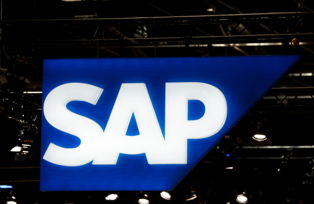 Sinal iluminado da SAP em azul e branco, pendurado em uma estrutura de palco escura.
