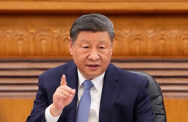 Xi Jinping, de terno e gravata, fala com o dedo indicador apontado para cima.