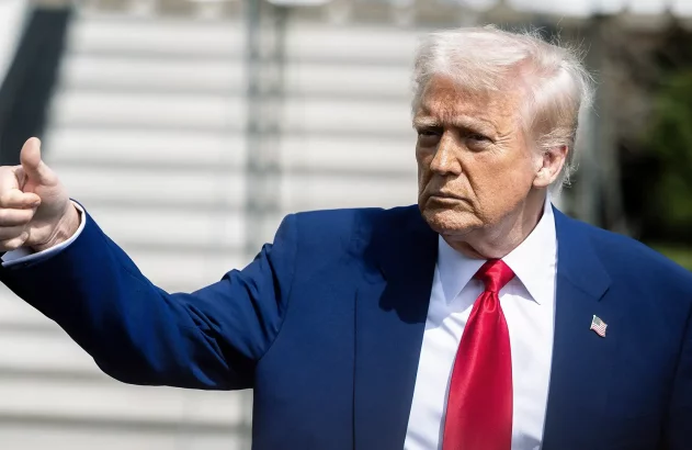 Donald Trump, de terno azul e gravata vermelha, faz um sinal de positivo.