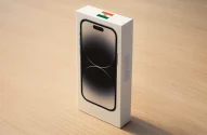 Caixa de smartphone com bandeira da Índia e inscrição "Made in India" sobre madeira clara.
