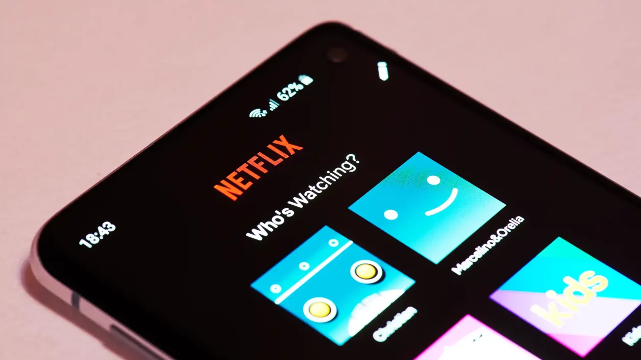 Tela inicial do aplicativo Netflix em smartphone com logotipo e perfis visíveis.
