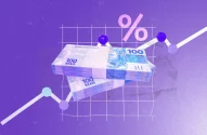 A imagem exibe um fundo roxo com textura granulada, com duas pilhas de notas de 100 reais centralizadas em ângulo, acima das quais se destaca um símbolo de porcentagem rosa. Ao fundo, uma linha de gráfico branca em ascensão se conecta a círculos azuis e roxos, sugerindo crescimento econômico em um tema financeiro.