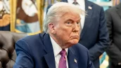 Trump está de terno azul e gravata roxa, olhando de lado, com cara de enfezado
