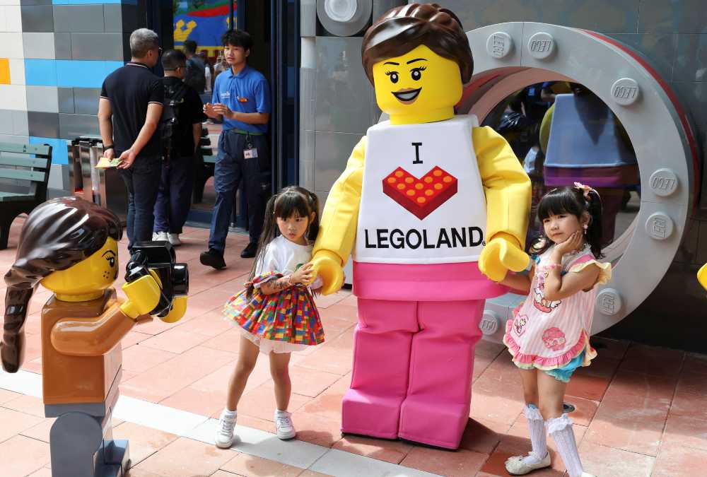 Crianças posam para foto com mascote em pré-inauguração do Legoland Shanghai Resort - Crédito: Reuters