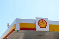 Imagem da fachada de um posto de gasolina com o céu azul ao fundo