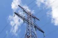 Topo de uma torre de transmissão de energia elétrica contra um céu azul