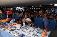 Foto ce um comerciante vendendo peças de casa, como torneiras, em uma feira em Cuba