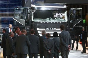 Imagem de homens de terno preto olhando para um caminhão da Iveco
