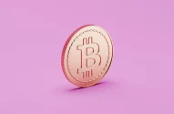 A imagem apresenta uma moeda com o símbolo do Bitcoin em destaque, posicionada sobre um fundo rosa sólido. A moeda possui um brilho metálico característico, com entalhes na borda e sombra ao fundo, enfatizando seu relevo e detalhes.