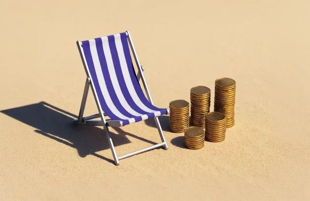 A imagem mostra uma cena na areia com uma cadeira de praia listrada em azul e branco à esquerda e pilhas de moedas douradas à direita, sob luz solar intensa, com sombras suaves e brilho das moedas destacando o conceito financeiro ou de férias.
