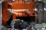 Imagem mostra um homem careca segurando uma grande pedra, que é meteriorito de Marte