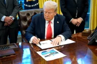 a man sitting at a desk writing on a piece of paper