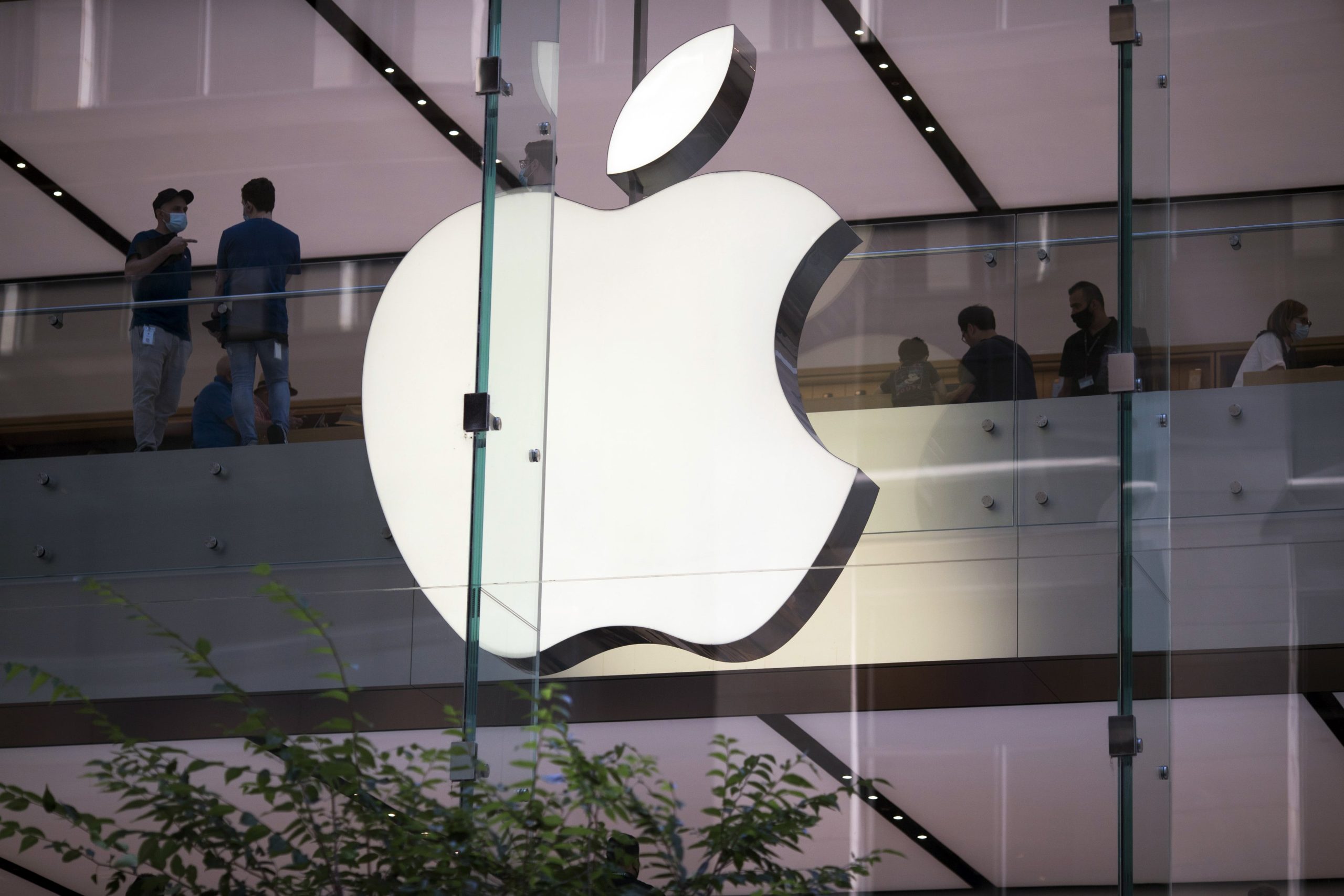 Logo iluminado da Apple, que lançará o iPhone 17 em setembro de 2025, em loja de vidro