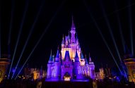 Imagem mostra o Castelo da Cinderela, na Disney, em uma noite. Castelo está iluminado com luz roxa