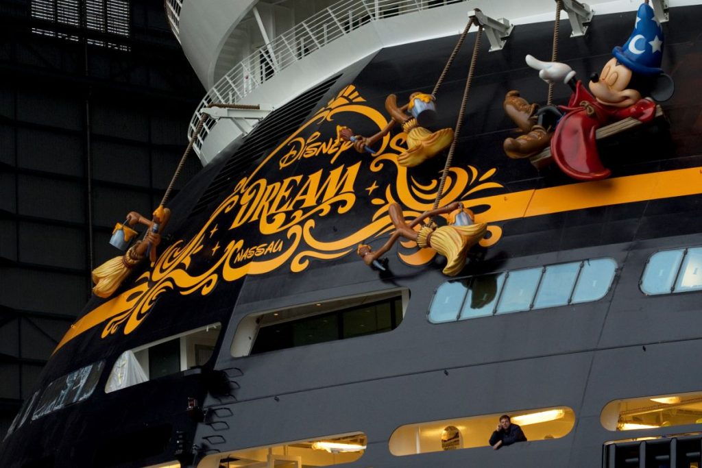 Imagem mostra o topo de um navio da Disney, cruzeiro é preto e está escrito Disney em dourado