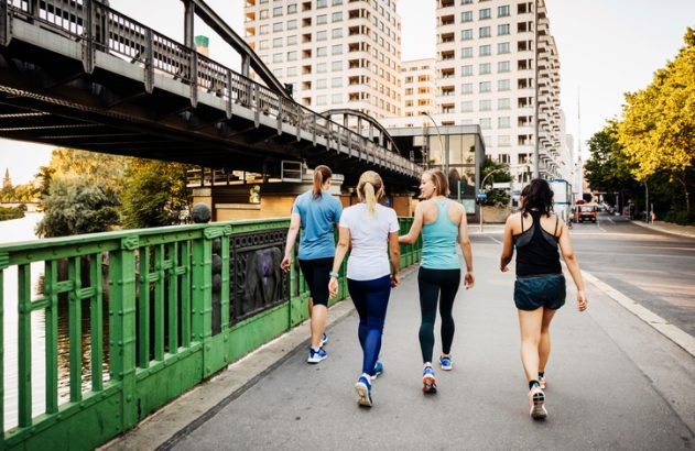 Um grupo de fitness para mulheres se refrescando depois de uma corrida pela cidade juntas. Imagem para ilustrar conteúdo sobre caminhada japonesa