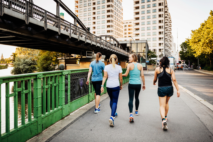 Um grupo de fitness para mulheres se refrescando depois de uma corrida pela cidade juntas. Imagem para ilustrar conteúdo sobre caminhada japonesa