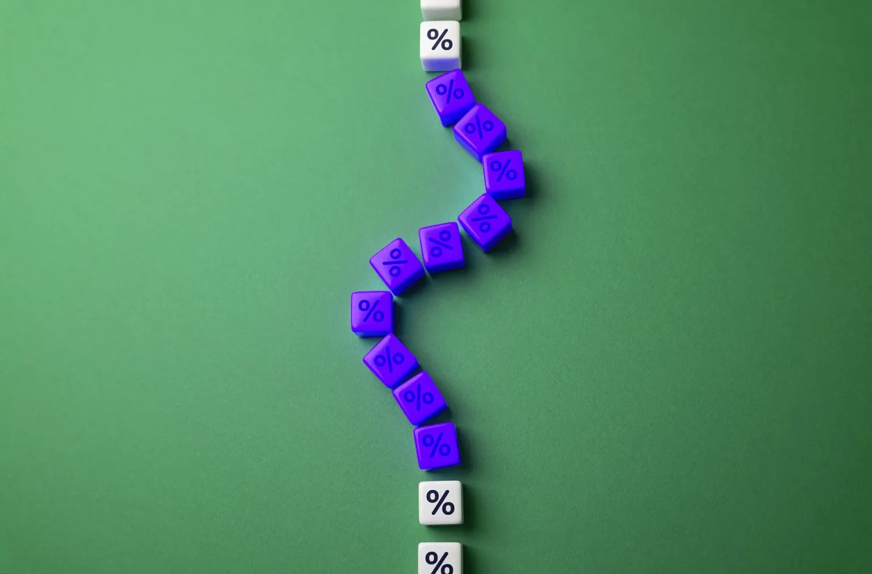 Cubos roxos com % branco e cubos brancos com % preto formam linha serpenteante sobre superfície verde, criando contraste visual marcante.