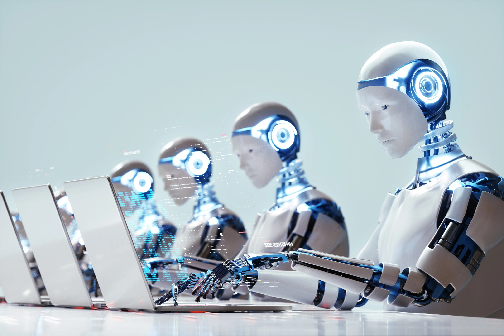 a group of robots working on laptops