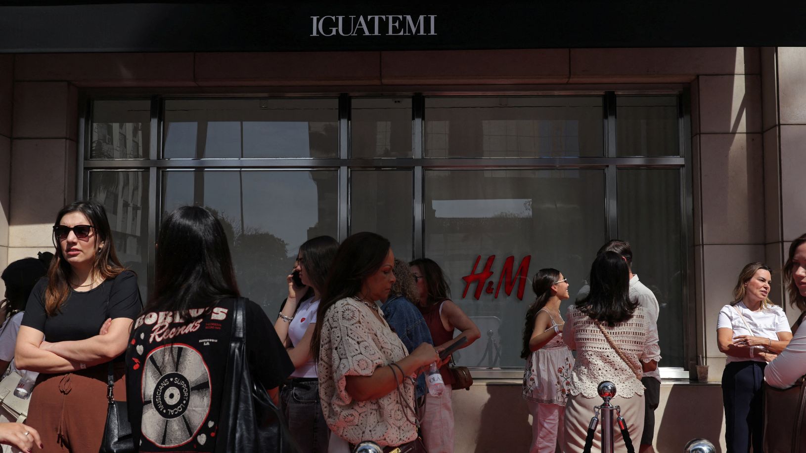 Mulheres formam fila em frente à vitrine da loja H&M no Shopping Iguatemi